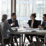 Busy millennial professional group reviewing startup marketing reports