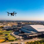 dron unoszący się nad panoramą miasta z wieżowcami i ulicami w tle
