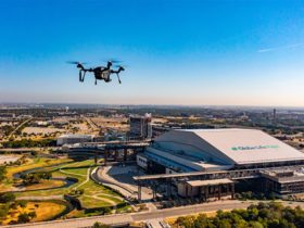 dron unoszący się nad panoramą miasta z wieżowcami i ulicami w tle