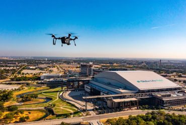 dron unoszący się nad panoramą miasta z wieżowcami i ulicami w tle