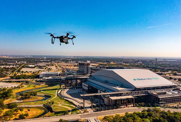 dron unoszący się nad panoramą miasta z wieżowcami i ulicami w tle