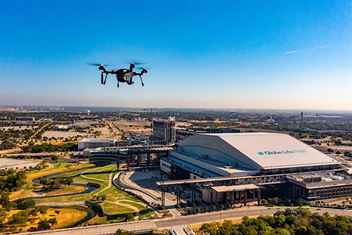 dron unoszący się nad panoramą miasta z wieżowcami i ulicami w tle
