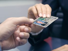 mężczyzna skanuje dowód osobisty smartfonem na biurku w nowoczesnym biurze