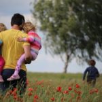 rodzice podpisujący dokumenty przy stole z uśmiechami