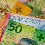 Szczęśliwa rodzina odbiera klucze do nowego domu z frankami szwajcarskimi w dłoniach